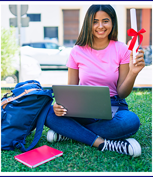 High school student sitting outside on a beautiful summer day with laptop and book